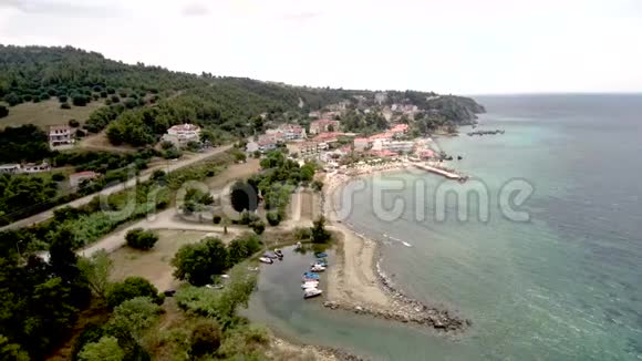 在Halkidiki希腊的AgiaParaskevi地区有一个小的自然港口和一个小海滩有一个码头的鸟瞰图移动为战视频的预览图
