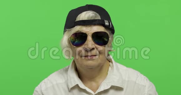 一位戴着太阳镜和帽子的老妇人微笑着老奶奶铬键视频的预览图