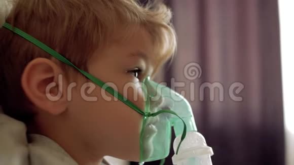 男孩通过吸入器的透明面罩呼吸那个男孩自己做鼻吸拍脸上的吸入面罩视频的预览图