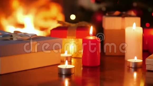 在客厅里用火棕榈树和圣诞树点燃蜡烛和装有圣诞礼物的盒子的4k娃娃镜头视频的预览图