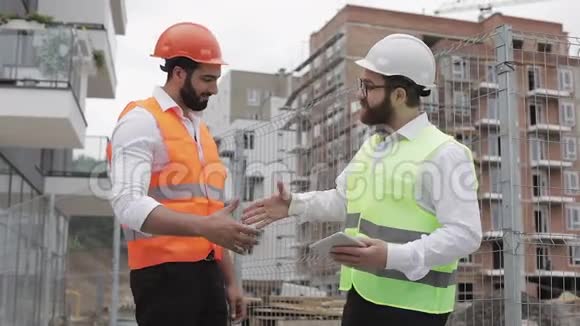 施工经理和工人在施工现场握手专业建筑工人建筑师视频的预览图