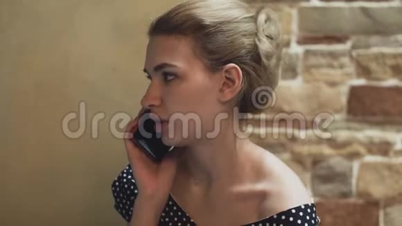 餐馆里一个穿晚礼服的年轻女人的肖像她用智能手机说话视频的预览图