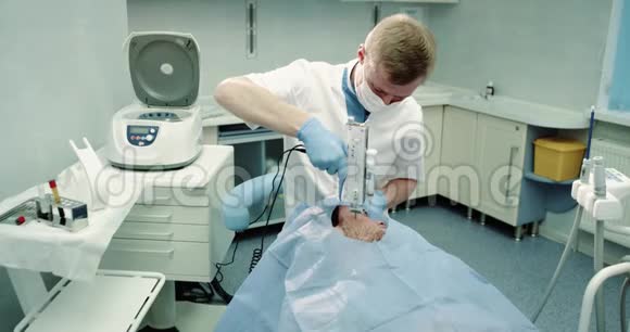 在美容室医生用一种现代的吸血鬼面部技术为病人做了现代面部护理视频的预览图