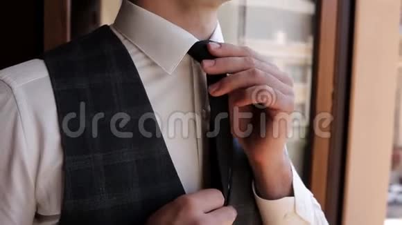 年轻时尚的男人穿着白色衬衫站着系着领带婚礼准备视频的预览图