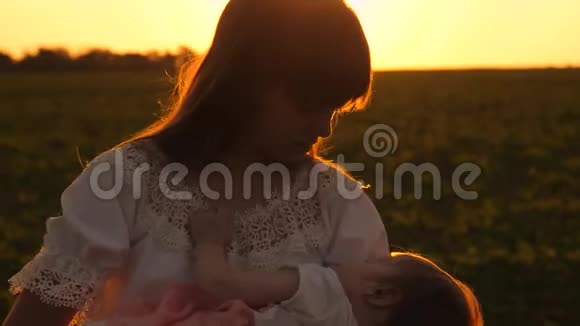 日落时分妈妈带着小孩在夏日公园散步孩子在妈妈的手睡着了慢镜头拍摄视频的预览图