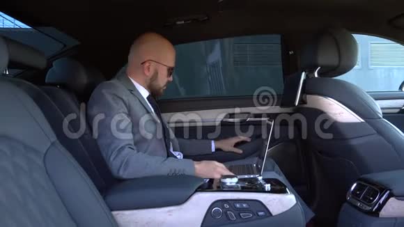 商务人员在行政车后座用笔记本电脑工作商业理念成功理念旅游理念奢华理念视频的预览图