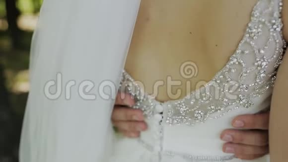 新娘和新郎拥抱男人抚摸女人赤裸的背部婚礼视频的预览图