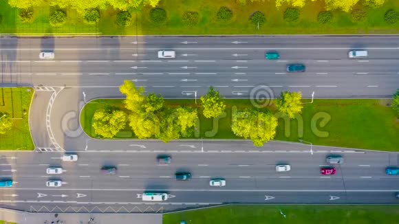 从上面可以看到城市公路在沥青路面上可以看到汽车运动的标记周围的风景和树木视频的预览图