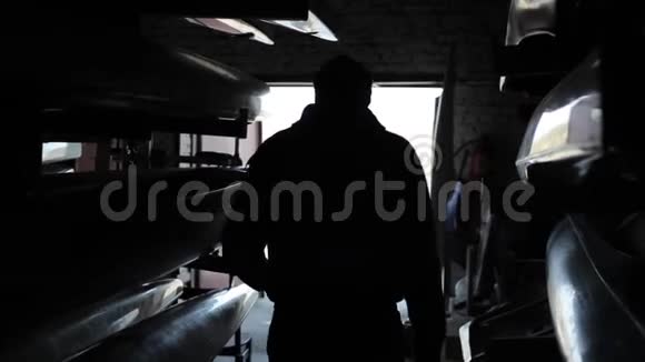 独木舟和皮艇一个人从黑暗中离开仓库进入光明视频的预览图
