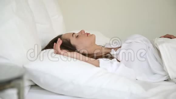 生病的女人在床上醒来触摸背部感觉疼痛视频的预览图