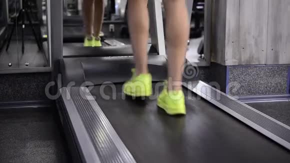 穿着运动鞋的女孩在跑步机上慢慢行走视频的预览图