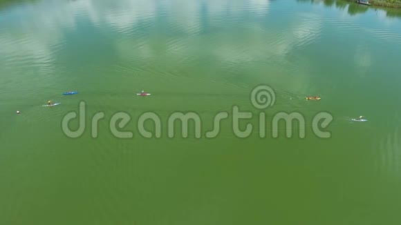 空中皮划艇和站起来的桨板在绿色水面上竞争视频的预览图