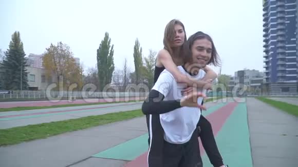 运动装户外可爱的一对运动装户外可爱的一对运动装帅哥背着一个女孩运动装情侣恋爱了视频的预览图
