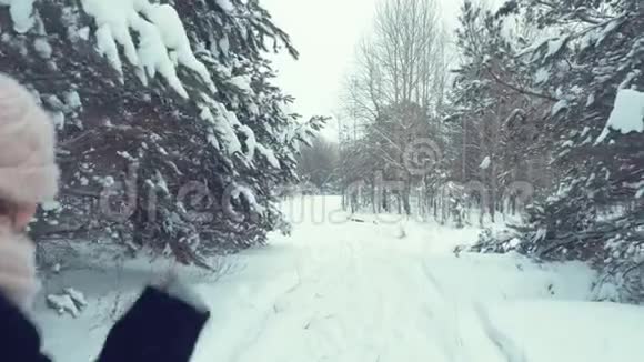 女人在冬天的树林里向前跑视频的预览图