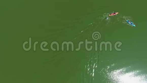 在水上竞赛中绕过浮标的彩色皮划艇上的划艇运动员的空中自上而下视频的预览图