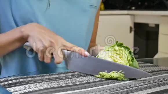 特写视频女性手在厨房桌子上的一块木板上剁白菜干净的饮食节食素食视频的预览图