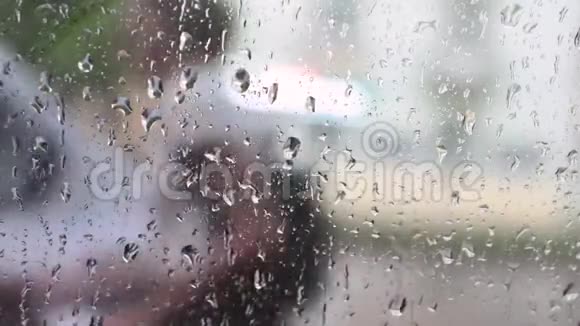 下雨了玻璃上的雨滴一男一女躲雨视频的预览图