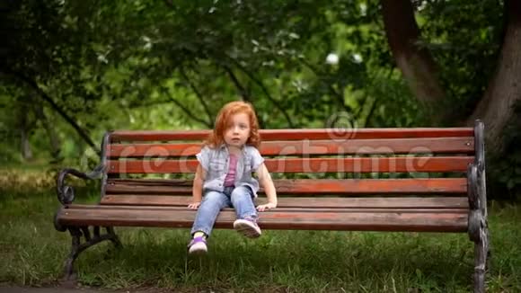 小可爱的女孩坐在长凳上视频的预览图