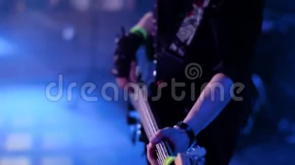 摇滚音乐会上一位低音吉他手的漂亮特写很漂亮的光在贝斯手上手套视频的预览图