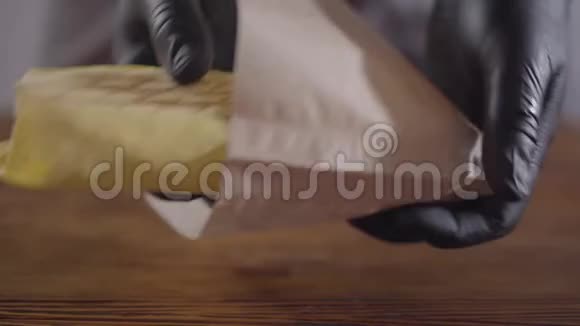 穿着黑色厨房手套的厨师把令人垂涎的卷放在纸袋里食品广告概念美味可口视频的预览图