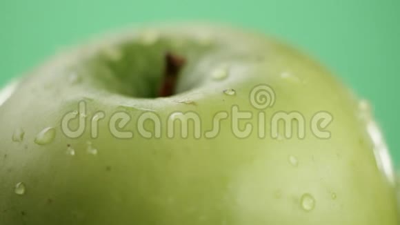 在视频中我们看到一个绿色的苹果在视频的中间水开始从顶部像淋浴一样倾泻下来绿色的视频的预览图
