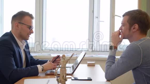 年轻人在办公室咨询专业律师背景背光视频的预览图