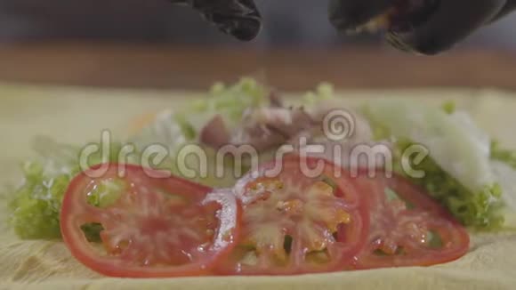 厨师的双手戴着黑色厨房手套制作沙瓦玛特写厨师把多汁的肉放在西红柿和洋葱上视频的预览图