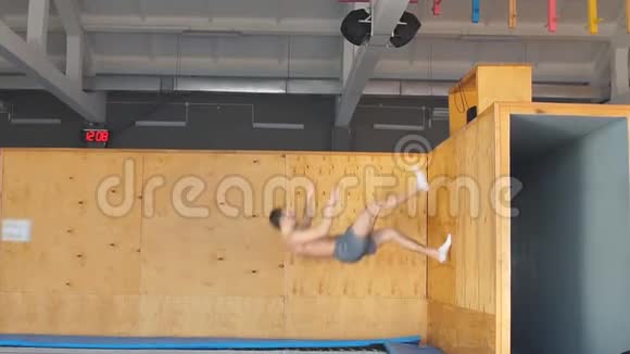 年轻的雄心勃勃的运动员在推掉木板后在空中做运动视频的预览图
