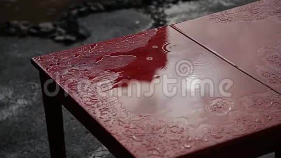 雨滴在一张红色的旧桌子上视频的预览图