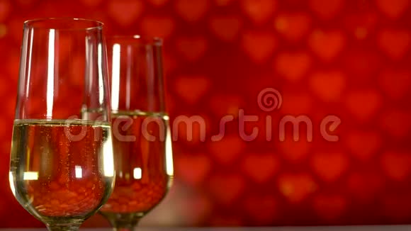情人节概念两杯带红葡萄酒的香槟酒心背景视频的预览图