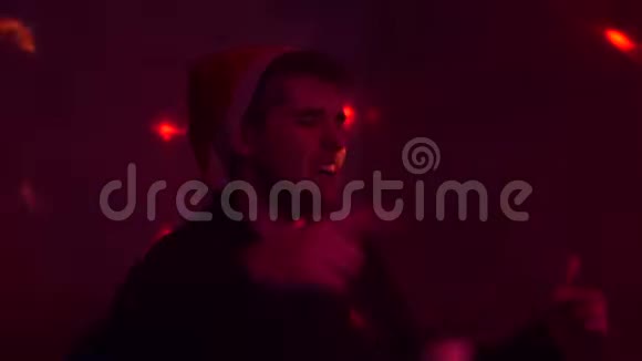 在派对上戴圣诞帽的人唱歌灯光像在俱乐部里一样闪烁五彩的光新年视频的预览图