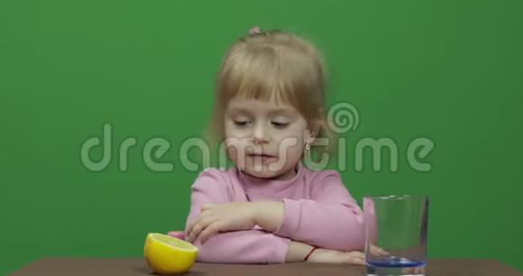 漂亮的小女孩脸上带着鬼脸捏着柠檬汁视频的预览图