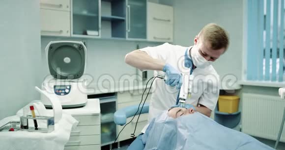 面部医生的现代技术为他的病人做了一个面部或吸血鬼面部的手术放置在蓝色上视频的预览图