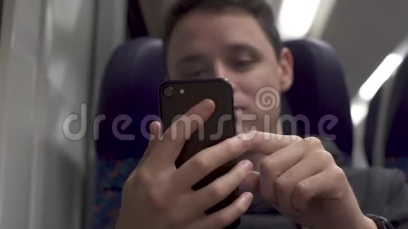 年轻人在火车上工作玩智能手机和音乐视频的预览图