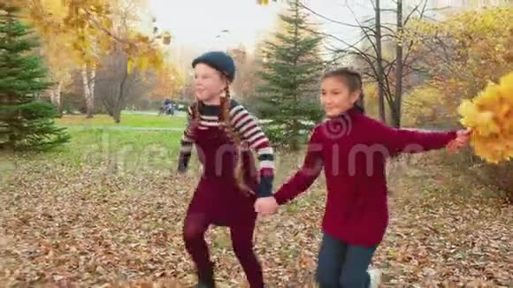 快乐的女孩在美丽的秋天公园一起奔跑视频的预览图