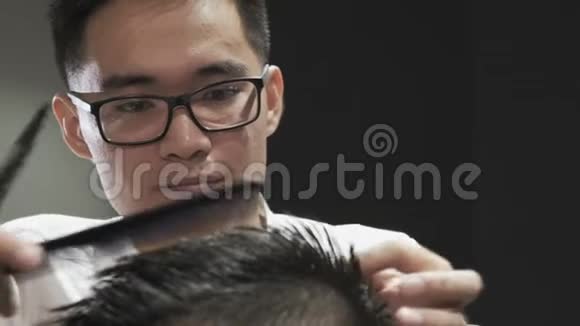 在沙龙中为客户做美发师手部梳理和剪发的特写视频的预览图
