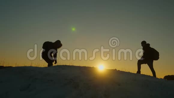 登山者在雪山顶上相遇享受他们的成功举起手快乐地跳跃男性游客视频的预览图