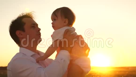 快乐的爸爸在公园里亲吻小女儿快乐童年的概念父亲带着小孩在阳光下玩耍视频的预览图