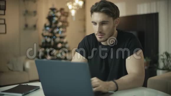 圣诞快乐的人在电脑上工作微笑的家伙在看电脑视频的预览图