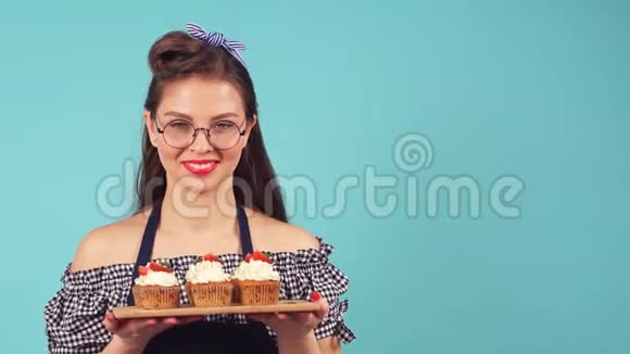 年轻女子手里拿着纸杯蛋糕的糕点师微笑着对着镜头视频的预览图