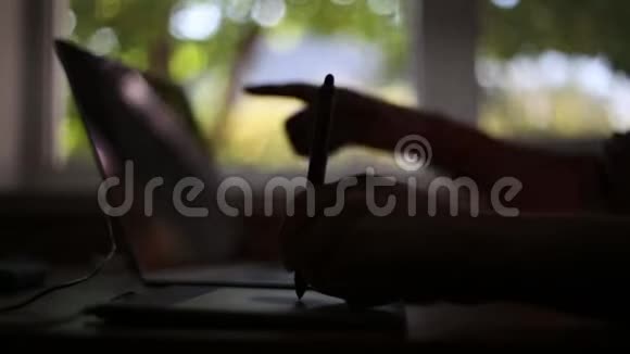 图形平板电脑的特写男性手在笔记本电脑键盘上打字视频的预览图