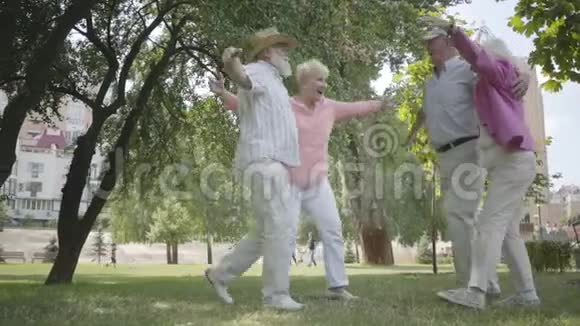 两对可爱的成年夫妇在公园里拥抱在一起围成一圈双人约会的高级夫妇友好的公司视频的预览图