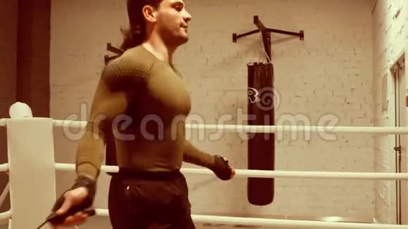 年轻的职业拳击手有运动的身体正在跳绳在环边视频的预览图