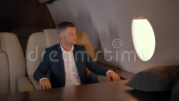 商人坐在商务飞机扶手椅上的肖像视频的预览图
