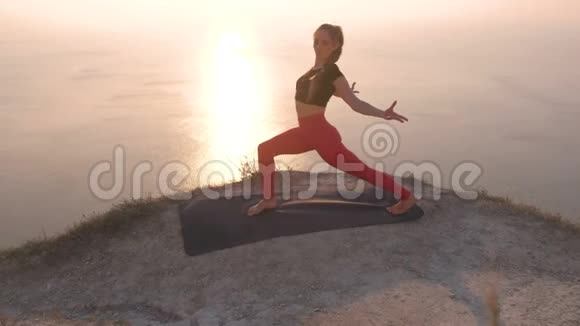 美丽的风景女人做瑜伽一条腿向下走的狗高午餐的狗在山上海景视频的预览图