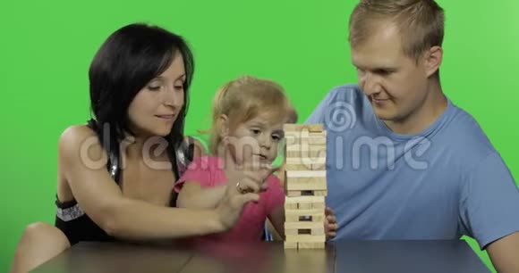 母亲父亲和女儿扮演简加从塔上拉出木块视频的预览图