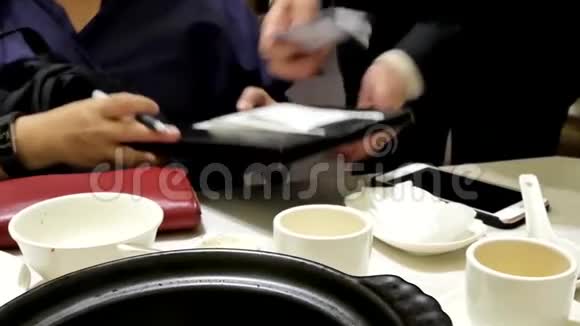 妇女就餐后签署收据的动议视频的预览图