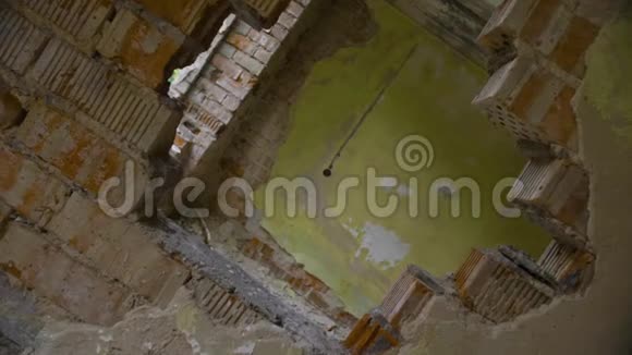 穿过废弃建筑墙上的洞旋转的视角视频的预览图