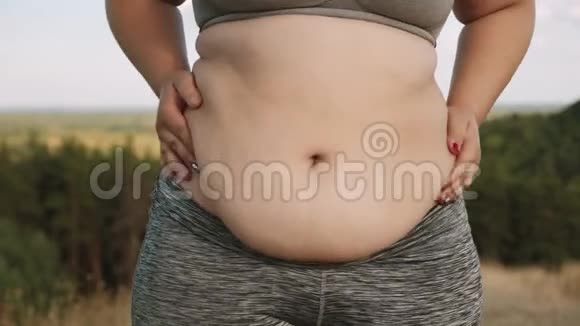 超重的女孩摇着她肥胖的肚子视频的预览图