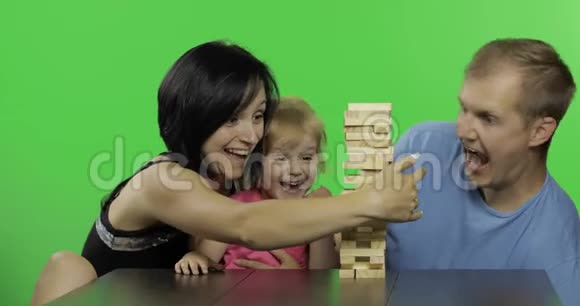 母亲父亲和女儿扮演简加从塔上拉出木块视频的预览图